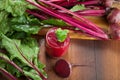 Glass of fresh beetroot juice with bets on wooden table. Royalty Free Stock Photo