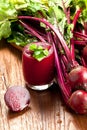 Glass of fresh beetroot juice with bets on wooden table. Royalty Free Stock Photo