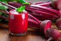 Glass of fresh beetroot juice with bets on wooden table. Royalty Free Stock Photo