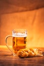 Glass of fresh bright beer with smoked cheese braid on sacking Royalty Free Stock Photo