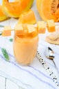 Glass of fresh cantaloupe smoothie on white wooden boards. Clos Royalty Free Stock Photo