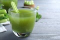 Glass of fresh celery juice on grey wooden table, closeup Royalty Free Stock Photo