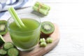 Glass of fresh celery juice on white wooden table, closeup. Space for text Royalty Free Stock Photo