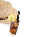 Glass of fresh coke with straw in front of summer hat, summer time Royalty Free Stock Photo