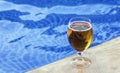 glass with fresh cold beer on pool edge Royalty Free Stock Photo