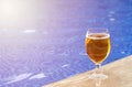 glass with fresh cold beer on pool edge Royalty Free Stock Photo