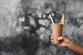 Glass of fresh cold chocolate milk shake in woman hands on gray background Royalty Free Stock Photo