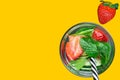 Glass with fresh cool infused water with ripe organic strawberries sliced cucumbers mint with straw on yellow background Royalty Free Stock Photo