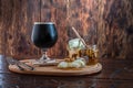 A glass of fresh dark beer. Chilled dark beer and cheese with honey. Cool beer stout. Serving beer and cheese Royalty Free Stock Photo