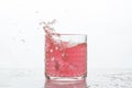 A glass of fresh drink with splashes on white