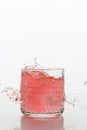 A glass of fresh drink with splashes on white background. Frozen motion.