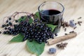 Glass of fresh elderberry syrup with ingredients