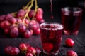 A glass of fresh grape juice, grape juice canning. Dark background, splashes and drops in a glass. Royalty Free Stock Photo