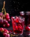A glass of fresh grape juice, grape juice canning. Dark background, splashes and drops in a glass. Royalty Free Stock Photo