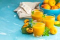 Glass of fresh healthy apricot juice in sunny light on blue surface Royalty Free Stock Photo