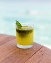 Glass of fresh juice or cocktail on table at beach Royalty Free Stock Photo