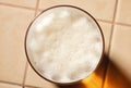 Glass of fresh lager beer with White fresh Foam on table. Beer foam top view. Bubble froth of beer