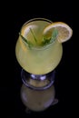 A glass of fresh lemonade, lemon juice. Cocktail with lemon slices and lemon slice on a black background. Copy space Royalty Free Stock Photo