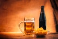 Glass of fresh light beer, a bottle beer and chips on a wooden table Royalty Free Stock Photo