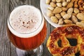 Glass of fresh light beer with salted pretzel and nuts on the wooden table Royalty Free Stock Photo