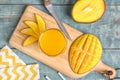 Glass of fresh mango juice and cut fruits on wooden table Royalty Free Stock Photo