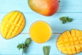 Glass with fresh mango juice and tasty fruits on wooden table Royalty Free Stock Photo