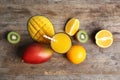 Glass with fresh mango juice and tasty fruits on wooden table Royalty Free Stock Photo