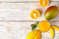 Glass with fresh mango juice and tasty fruits on wooden table, flat lay. Royalty Free Stock Photo