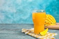 Glass of fresh mango juice and tasty fruits on wooden table. Royalty Free Stock Photo