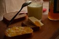 Glass of fresh milk ,spoon with apricot jam and butter .