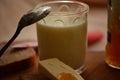 Glass of fresh milk ,spoon with apricot jam and butter .