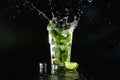 Glass of fresh mojito with splashes on dark background Royalty Free Stock Photo