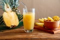 Glass of fresh natural pineapple juice with metal reusable tube on brown wooden table with ingredients. Fruit Pineapple Royalty Free Stock Photo