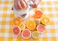 Glass of fresh orange and grapefuit juice made with squeezer and natural fresh fruits. Yellow checkered tableclock. Break of Royalty Free Stock Photo