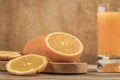 Glass of fresh orange juice and oranges on cutting board Royalty Free Stock Photo