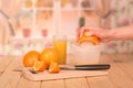 A glass orange juice, oranges, and pieces of female hand holding Royalty Free Stock Photo