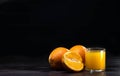 glass of fresh orange juice and oranges on a vintage wooden background. For the design signiture Royalty Free Stock Photo