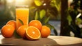 Glass of fresh orange juice and ripe oranges on wooden table in sunlight Royalty Free Stock Photo