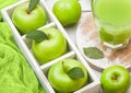 Glass of fresh organic apple juice with granny smith green apples in box on wooden background Royalty Free Stock Photo