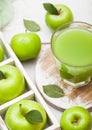 Glass of fresh organic apple juice with granny smith green apples in box on wooden background Royalty Free Stock Photo
