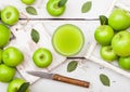 Glass of fresh organic apple juice with granny smith green apples in box on wooden background with knife Royalty Free Stock Photo