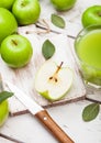 Glass of fresh organic apple juice with green apples on wooden background with knife Royalty Free Stock Photo