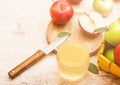 Glass of fresh organic apple juice with pink lady red and granny smith green apples on chopping board on wooden background with kn Royalty Free Stock Photo