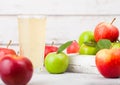Glass of fresh organic apple juice with red and green apples in box on wooden background Royalty Free Stock Photo