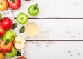 Glass of fresh organic apple juice with red and green apples in vintage box on wooden background Royalty Free Stock Photo