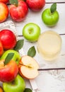 Glass of fresh organic apple juice with red and green apples in vintage box on wooden background Royalty Free Stock Photo