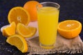 A glass of fresh organic orange juice on a dark background. Close-up. Royalty Free Stock Photo