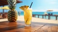 A glass with a fresh pineapple cocktail stands on a table, on a background on the beach and sea Royalty Free Stock Photo