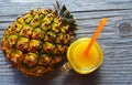 Glass of fresh pineapple juice and ripe pineapple fruit on rustic wooden table.Freshly squeezed pineapple juice with drinking stra Royalty Free Stock Photo