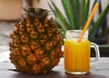 Glass of fresh pineapple juice and ripe pineapple fruit on rustic wooden table.Freshly squeezed pineapple juice with drinking stra Royalty Free Stock Photo